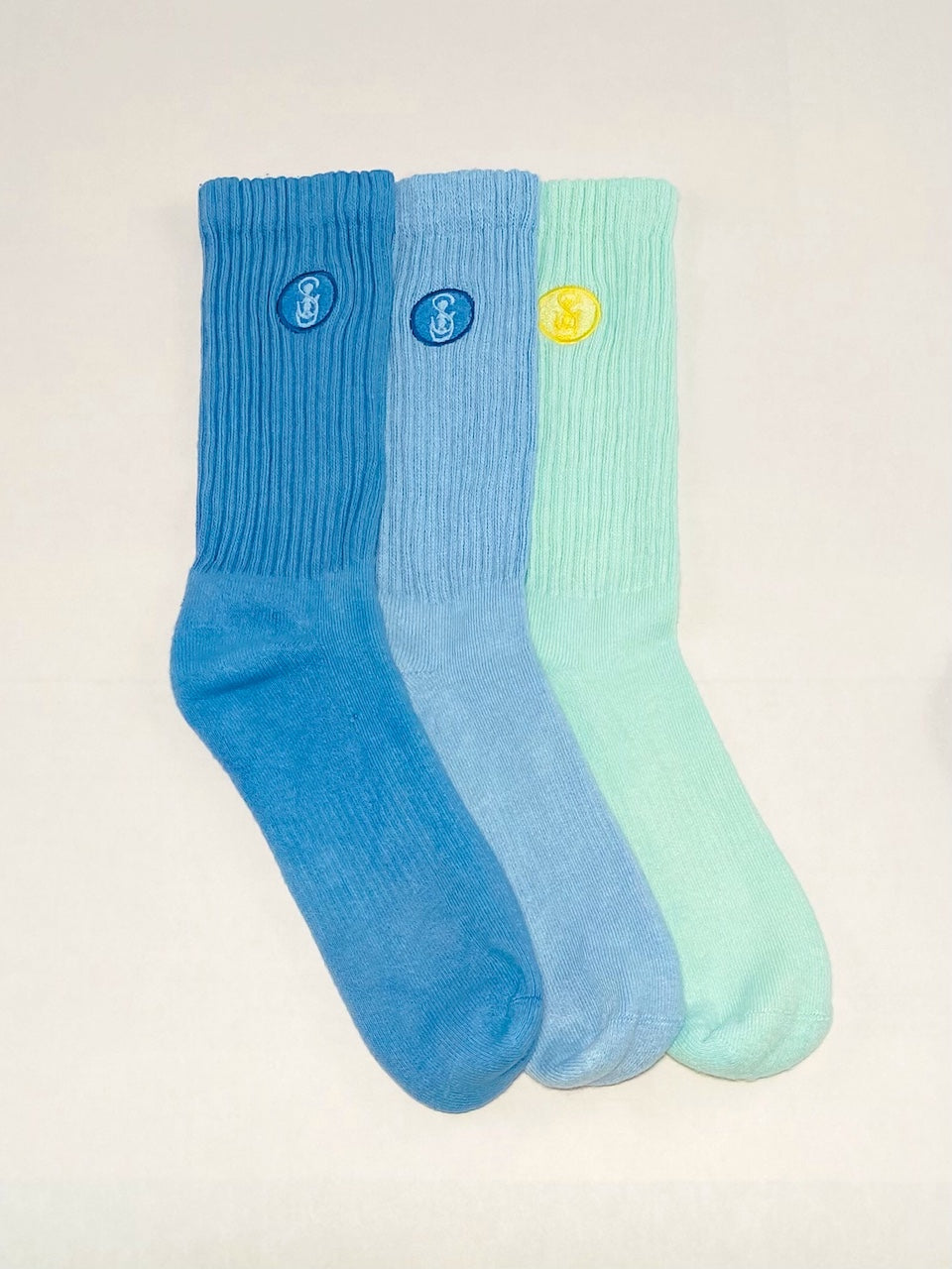 Three blue, light blue, and aqua crew socks.