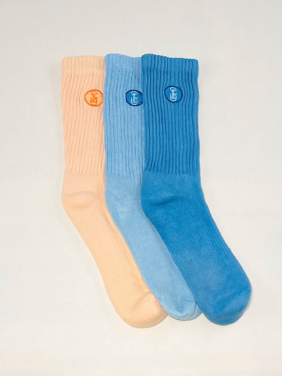 Three orange, light blue, and blue crew socks.