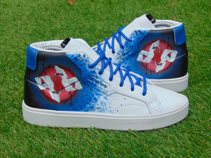 Custom painted Japanese crane shoes sitting on grass.