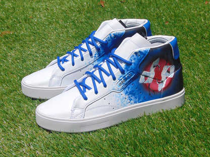 Custom painted Japanese crane shoes sitting on grass.