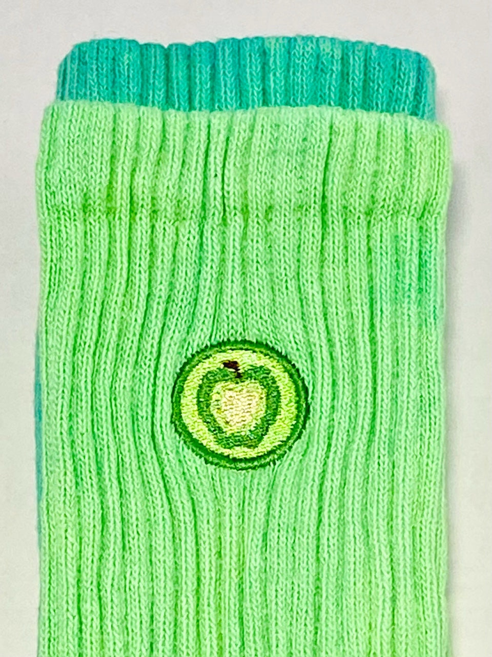 Light green hand dyed crew sock embroidered with a green apple.