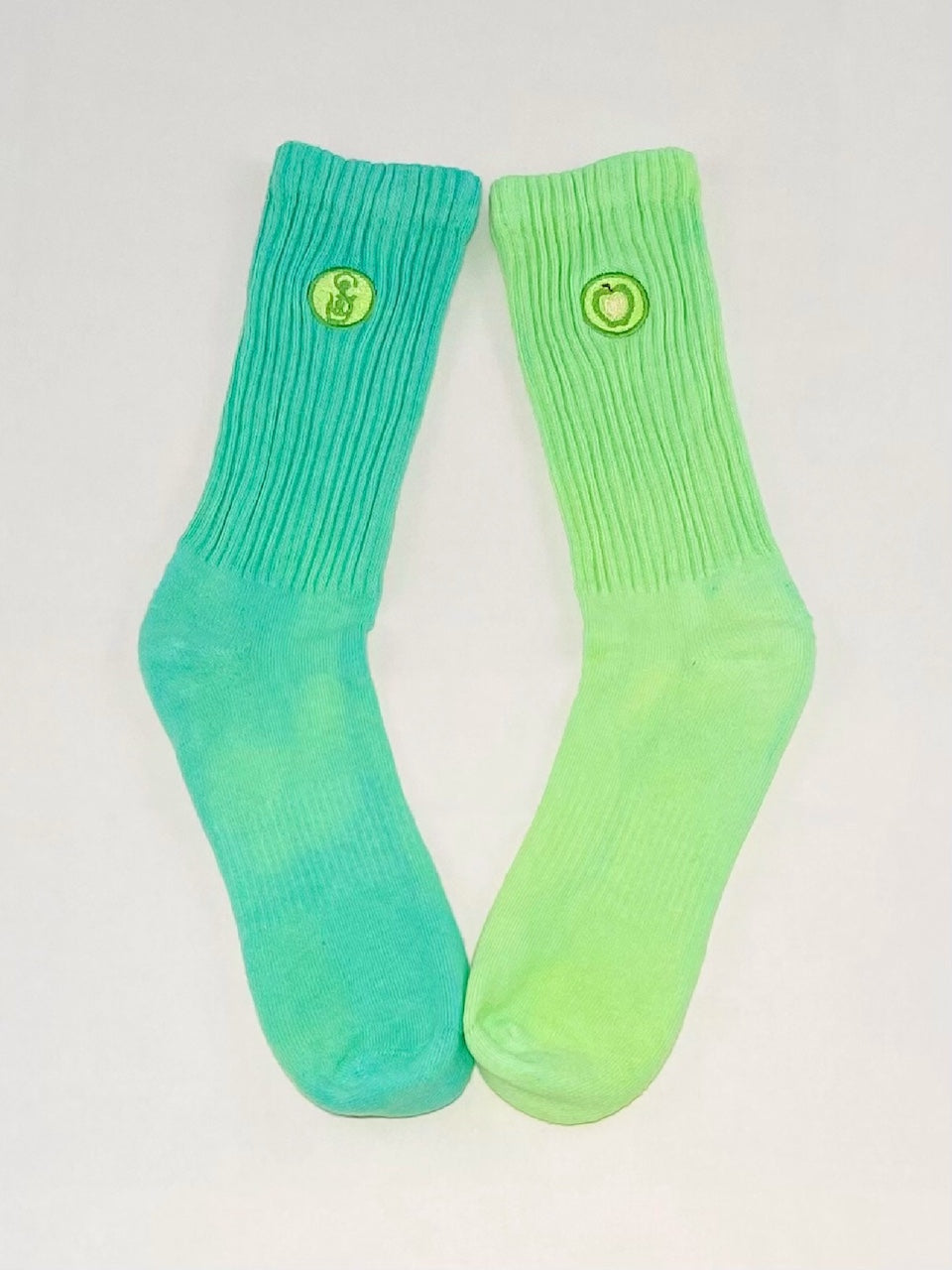 One pair of mismatch green hand dyed crew socks.