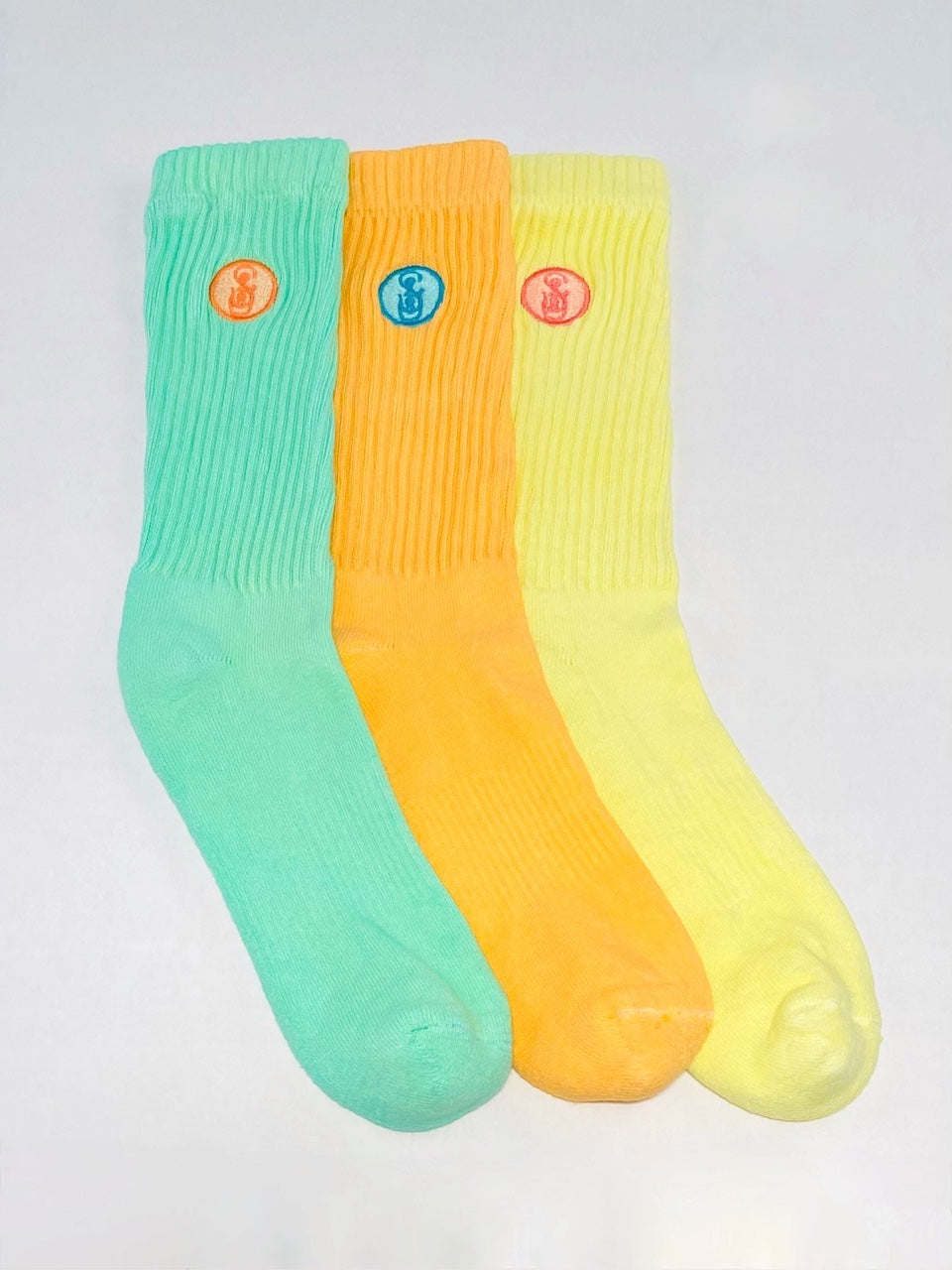 Three green, orange, and yellow crew socks.