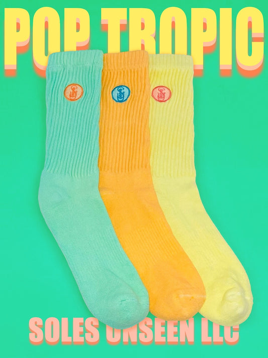 Three green, orange, and yellow crew socks with a green background.