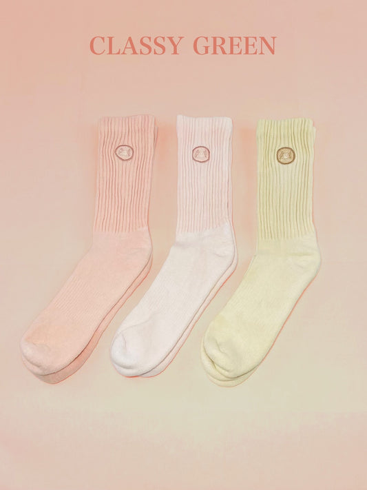Three pink, light pink, and tan hand dyed crew socks.
