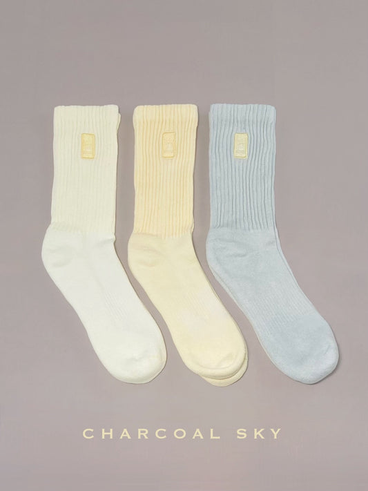 Three light yellow, yellow, and blue hand dyed crew socks.