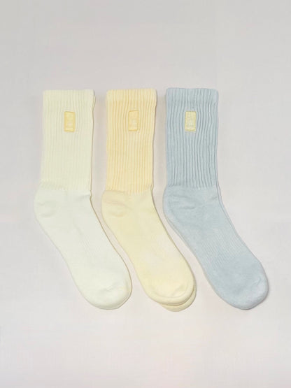 Three light yellow, yellow, and grey hand dyed crew socks.